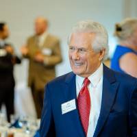 Guest standing and smiling at the Foundation Annual Meeting